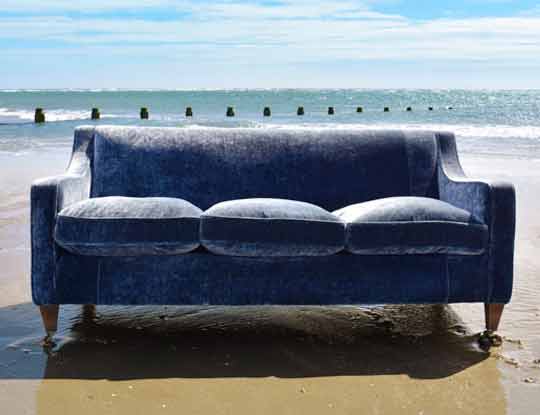 blue crushed velvet sofa on the beach