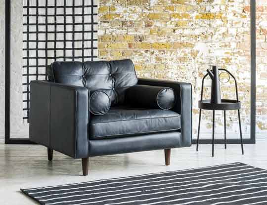 black leather armchair with brick background